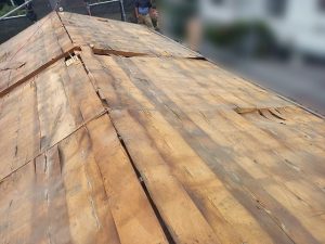 屋根下地に雨水が入り込んで腐食と変形が進行している様子
