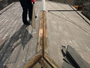 作業員が棟板金を取り外している様子