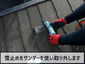 錆びた雪止めをサンダーで撤去している様子