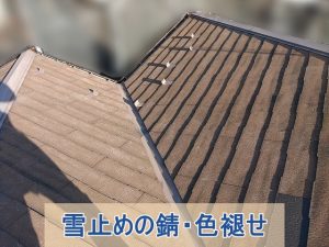 雪止めの錆と色褪せが見られるスレート屋根