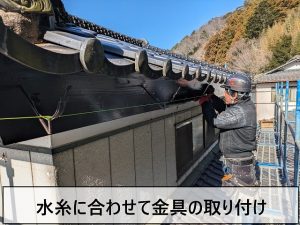 勾配が決まってから水糸に合わせて金具を打ち付けているところ