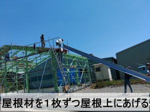 福島県郡山市　新しい倉庫の屋根に取り付ける折半屋根材を屋根に上げているところ
