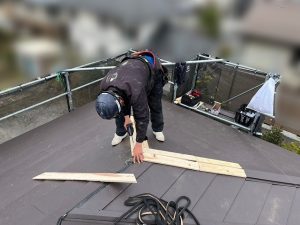 貫板をビスで固定している作業員